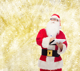 Image showing man in costume of santa claus with notepad