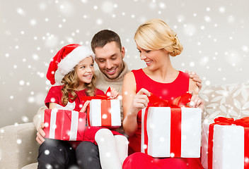 Image showing smiling family holding many gift boxes