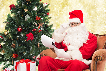 Image showing man in costume of santa claus with notepad