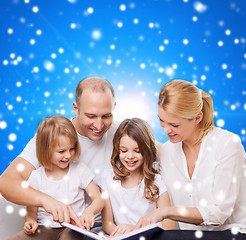 Image showing happy family with book at home