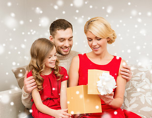 Image showing smiling family looking into open gift box