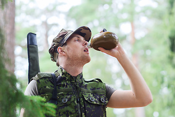 Image showing young soldier with gun and flask in forest