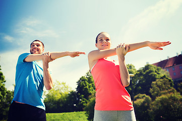 Image showing smiling couple stretching outdoors