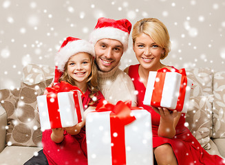 Image showing smiling family holding many gift boxes