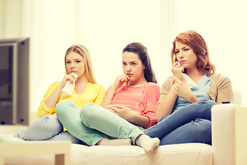 Image showing three sad teenage girl watching tv at home