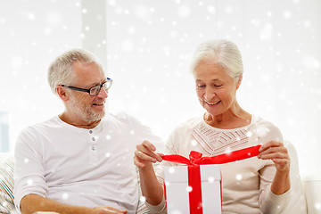 Image showing happy senior couple with gift box at home