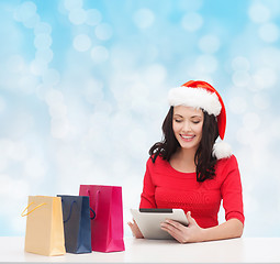 Image showing smiling woman with shopping bags and tablet pc