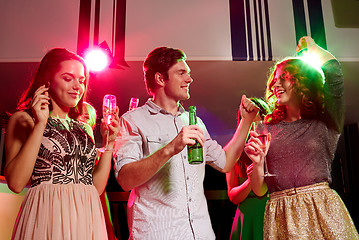 Image showing smiling friends with wine glasses and beer in club