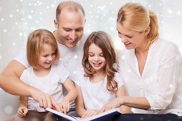 Image showing happy family with book at home