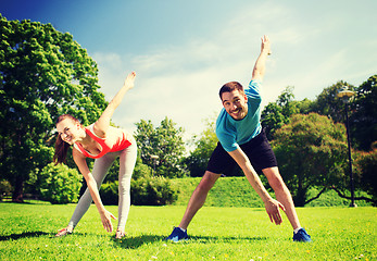 Image showing smiling couple stretching outdoors