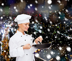 Image showing smiling female chef with pan and spoon