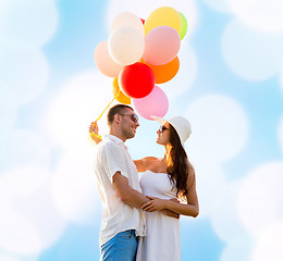 Image showing smiling couple with air balloons outdoors