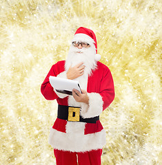 Image showing man in costume of santa claus with notepad