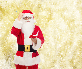 Image showing man in costume of santa claus with notepad