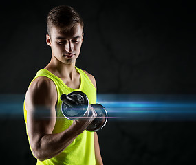 Image showing young man with dumbbell flexing biceps