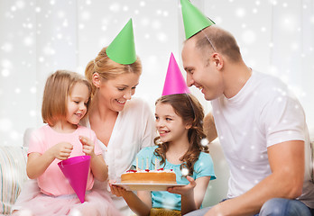 Image showing happy family with two kids in party hats at home