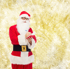 Image showing man in costume of santa claus with notepad