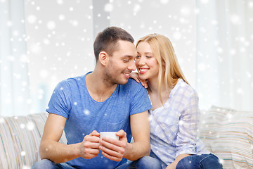 Image showing smiling couple with cup of tea or coffee at home