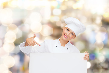 Image showing smiling female chef with white blank board