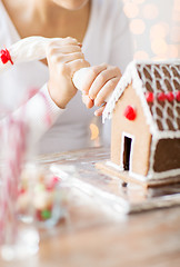 Image showing close up of woman making gingerbread house at home