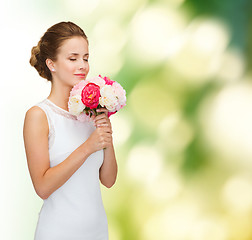 Image showing smiling woman in white dress with bouquet of roses