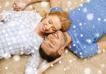 Image showing happy couple lying on floor head to head at home