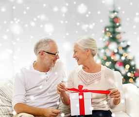 Image showing happy senior couple with gift box at home