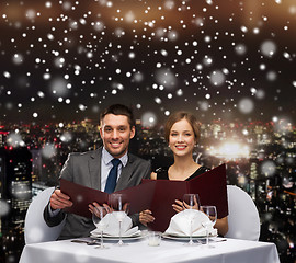 Image showing smiling couple with menus at restaurant