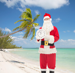 Image showing man in costume of santa claus with clock