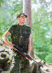 Image showing young soldier or hunter with gun in forest