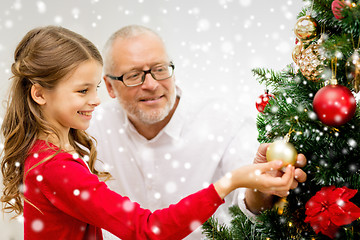 Image showing smiling family decorating christmas tree at home