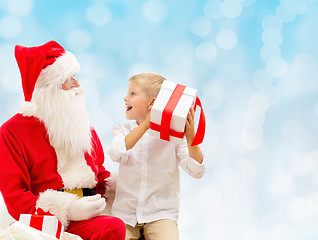 Image showing smiling little boy with santa claus and gifts