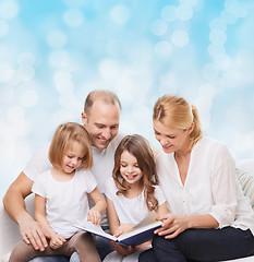 Image showing happy family with book at home