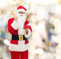 Image showing man in costume of santa claus with notepad