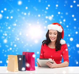 Image showing smiling woman with shopping bags and tablet pc