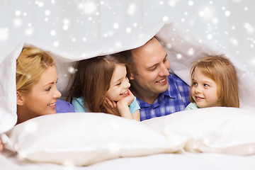 Image showing happy family with two kids under blanket at home