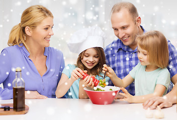 Image showing happy family with two kids making salad at home