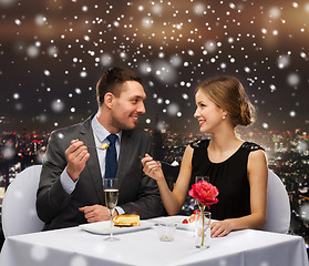 Image showing smiling couple eating dessert at restaurant