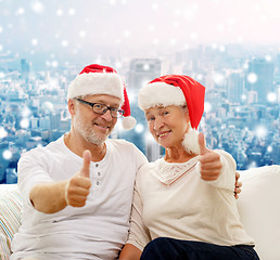 Image showing happy senior couple in santa helper hats