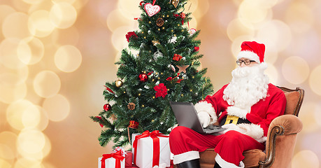 Image showing man in costume of santa claus with laptop