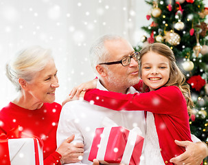 Image showing smiling family with gifts at home