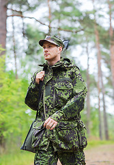 Image showing young soldier or hunter with gun in forest