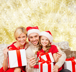 Image showing happy family in santa helper hats with gift boxes