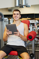 Image showing smiling young man with tablet pc computer in gym