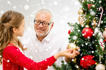 Image showing smiling family decorating christmas tree at home