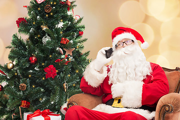 Image showing santa claus with smartphone and christmas tree