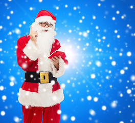 Image showing man in costume of santa claus with notepad