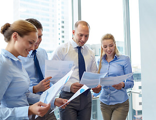 Image showing smiling businesspeople with papers in office