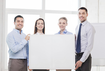 Image showing business team in office with white blank board