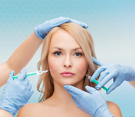 Image showing woman face and beautician hands with syringes